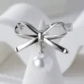Exquisito broche plateado de lazo con perla blanca colgante, elegante accesorio de moda. - Plateado