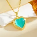 Gold heart pendant necklace detail shot, featuring a turquoise cat eye stone and delicate chain. - Blue Zirconia Heart Necklace / Gold