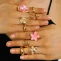 Vista dettagliata di un set di anelli in oro vintage con perla barocca e fiori rosa - Set di Anelli Perla Barocca Elemento Oceano (4098) / Rosa e Oro