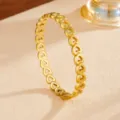 Close-up detail of the elegant hollow heart gold stainless steel fashion bangle bracelet. - Gold Hollow Heart Bangle (G415) / Gold