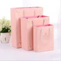 Roze papieren geschenkzak detailweergave, decoratief hartpatroon en stevige touwhandvatten. - 20x15x7cm / Roze