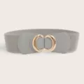 Nahaufnahme des elastischen Damen Taillengürtels mit schicker goldener Metallringschließe. - Goldene Schnalle Grau