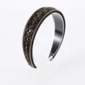 Detailed close-up of a sparkling black Baroque crystal headband with exquisite gold chain trim. - Black