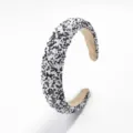 Primer plano de una diadema ancha elegante con cuentas en blanco y negro, textura fina. - Blanco