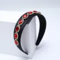 Detailed close-up of the baroque style black rhinestone headband featuring vibrant red gemstones. - Red
