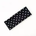 Dettaglio di una fascia sportiva elastica e alla moda a pois neri e bianchi per capelli. - pois neri