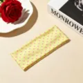 Vista dettagliata di una affascinante fascia gialla con pois rosa, accessorio per capelli. - Giallo a pois