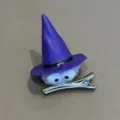 Close-up detail of a cute cartoon witch hat hair clip with googly eyes and fuzzy body. - Purple Duckbill Clip