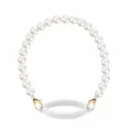 Pearl cup strap detail showing smooth white beads, golden lobster clasp, and flexible silicone ring. - White