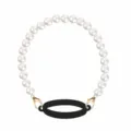 Pearl cup strap detail showing golden lobster clasps and black silicone ring connector. - Black