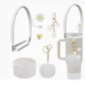 Stanley cup accessories set featuring silicone boot, daisy straw cover, and cute charm strap. - White