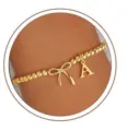 Gold beaded bow letter bracelet detail showing refined charm and elegant wrist wear. - Letter A
