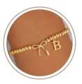 Close-up view of the lovely gold beaded stretch bracelet with bow and letter B charm. - Letter B