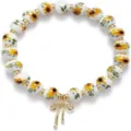 Detailed view of white ceramic sunflower beaded bracelet with gold bow charm and crystal. - Sunflower Style 6