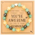 Close-up detail of beaded bracelet with green and yellow stones on inspirational message card. - Yellow-Green Agate + AWESOME Card