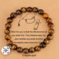 Primer plano de pulsera de cuentas de piedra natural con dije de brújula y tarjeta de graduación. - Colgante de Brújula de Aleación / Ojo de Tigre Amarillo