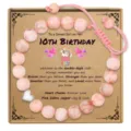 Detailed close-up of pink zebra jasper beaded bracelet with silver heart charm and gift card. - 10th Birthday