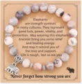 Detail shot of natural stone beaded bracelet with cute elephant charm and inspiring card. - Style 1