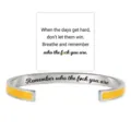 Detailed view of the stainless steel cuff bracelet with yellow enamel and engraved quote. - Yellow Steel-Remember