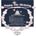 Kids birthday beaded bracelet with pink pearls and heart pendant on greeting card gift. - Happy 5th