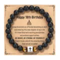 Detalle de pulsera de obsidiana mate con dije de cruz de acero y piedra de ojo de tigre. - Estilo 18 Cumpleaños