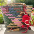 Nahaufnahme der handgefertigten gewebten Tasche mit Bambusgriffen und Häkelpuppen-Anhänger. - Chili-Männchen-Anhänger