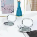 Specchio per trucco pieghevole bifacciale in metallo portatile, piccolo specchio cosmetico. - Ovale / Argento