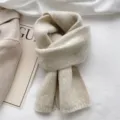 Close-up detail of cozy knit winter scarf in soft beige showing warm knitted texture. - Beige