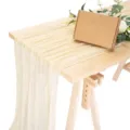 Detailansicht des beige-farbenen, transparenten Mull-Tischläufers auf Holztisch mit Dekoration. - 90*300cm / Beige