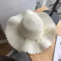 Close up detail of women summer straw sun hat with pearl and bow for beach vacation - M (56-58cm) / White