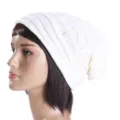 Detailed view of white knitted slouchy beanie hat, showcasing soft texture and warm design. - One Size / White