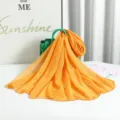Details of the yellow pleated scarf with shimmering silver threads, elegant draped fabric texture. - Silver Thread Ginger Yellow