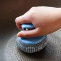 Detail shot of cleaning brush with blue handle in pot showing practical kitchen tool design. - Handle + Ball Set (Random Color)