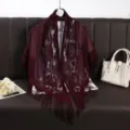 Detail of burgundy lace hollow-out fringe shawl featuring exquisite floral patterns and soft fabric. - Burgundy