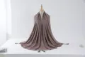 Detail view of a shimmering silver-trimmed hijab scarf with tassel beads on a mannequin stand. - Size 14