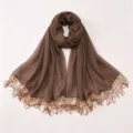 Detail view of the brown chiffon hijab scarf featuring elegant sequined tassel edges and soft fabric. - For A06