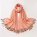 Detailed view of the peach chiffon hijab showcasing sequin embroidery and delicate tassels. - A02