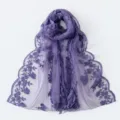 Close-up view of the delicate floral embroidery and sheer lace texture on this purple scarf. - Purple