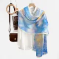 Detail view of a blue yellow gradient cutout sheer sun protection shawl scarf hanging nicely. - 17#