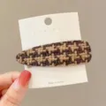 Close-up view of the brown houndstooth hair clip detail, featuring tweed fabric and secure metal clip. - Teardrop / Dark Coffee