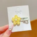 Close up of a sweet jelly yellow flower hair clip, resin floral design with duckbill clip. - Yellow Wave Flower Clip