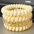 Detailed close-up of clear yellow telephone wire hair ties set with cute polka dot patterns. - Coconut 4-Piece Set (Yellow)