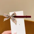 Detailed view of a sweet plaid ribbon bow hair clip with red velvet texture and card. - Red Velvet Khaki Plaid