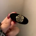 Μαύρο βελούδινο κλιπ μαλλιών με χρυσή καμέλια λεπτομέρεια, κοντινή ρετρό λήψη. - Χρυσή Καμέλια