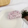 Vue détaillée d'une charmante pince à cheveux en acétate floral rose pour coiffures douces. - Demi-cercle à fleurs