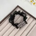 Λεπτομέρεια μαύρου scrunchie από δίχτυ με κομψή λαμπερή ορθογώνια λεπτομέρεια από στρας. - Μαύρο