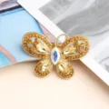 Gros plan détaillé sur une élégante broche papillon en strass étincelante avec des cristaux jaunes. - Jaune