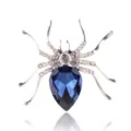 Zilverkleurige kristallen spinnenbroche met een diepblauwe peervormige strass-steen. - Zilver + Inktblauw