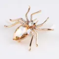 Prachtige goudkleurige spinnenbroche met champagnekristal en sprankelende strass-steentjes. - Goud + Champagne