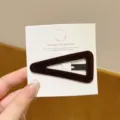 Close-up detail of dark brown velvet triangle hair clip with white card display, stylish accessory. - Triangle / 1 Piece / Coffee